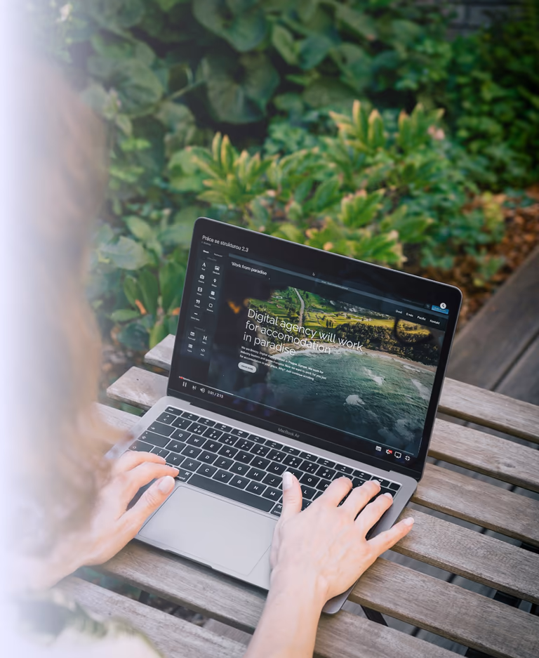 A website being built on a laptop in a leafy outdoor workspace